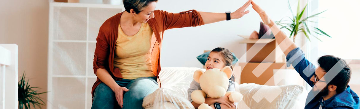 Família aparentemente felizes, sentados em um sofá mexendo em um tablet que está na mão da mãe