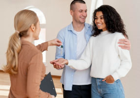 pessoa segurando uma chave com uma bonita casa ao fundo